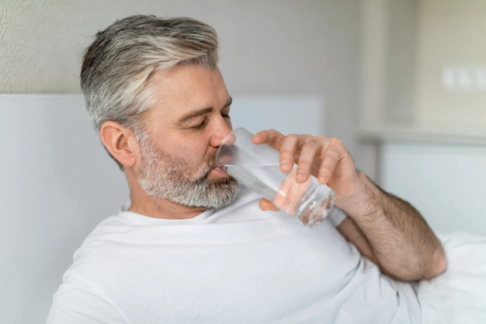 Hombre tomando agua como parte de las recomendaciones médicas después de su recuperación post daddy makeover para mantener una buena hidratación