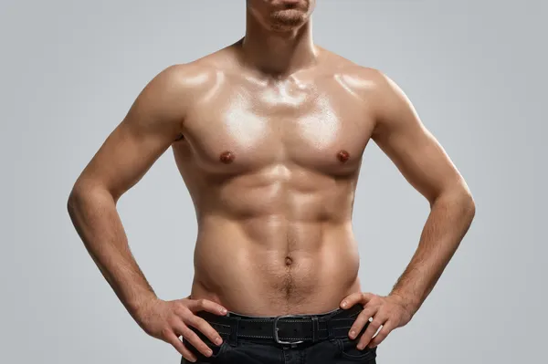 Fotografía de un hombre que muestra un abdomen ligeramente definido con resultados visibles obtenidos por la lipoescultura hombre