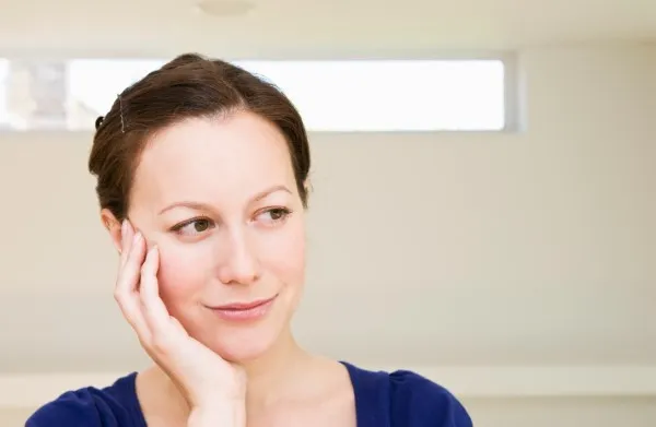 Adulta contenta con la suavidad y elasticidad de su piel después de procedimiento de rejuvenecimiento facial.