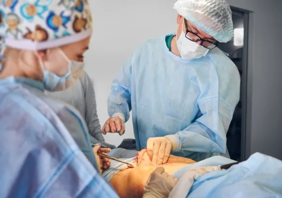 Dos de los mejores cirujanos plásticos de México colaboran en una abdominoplastia con instrumental quirúrgico especializado en el quirófano.