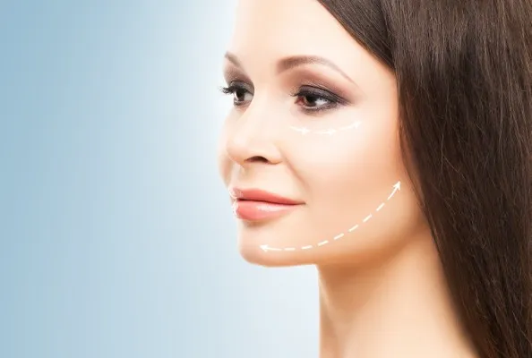 Procedimiento de lifting facial precio: mujer de edad avanzada muestra su rostro con líneas guía preparada para la cirugía Lifting facial precio en mujer frente a fondo azul con líneas de incisión blancas antes de su procedimiento estético